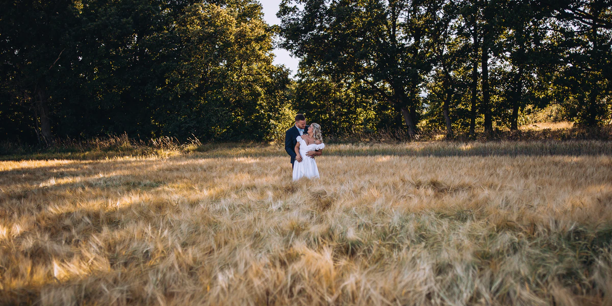 Novomanželé na louce při západu slunce